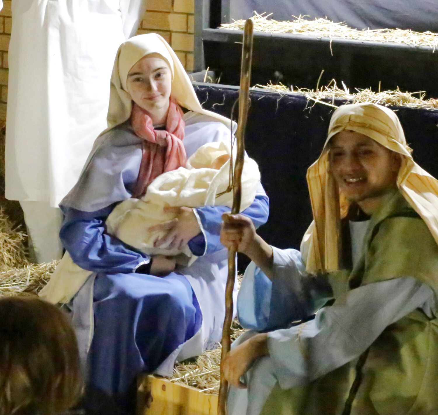 Mary, flanked by Joseph, cradles the baby Jesus at the Harvest Acres Baptist Church Living Nativity.
